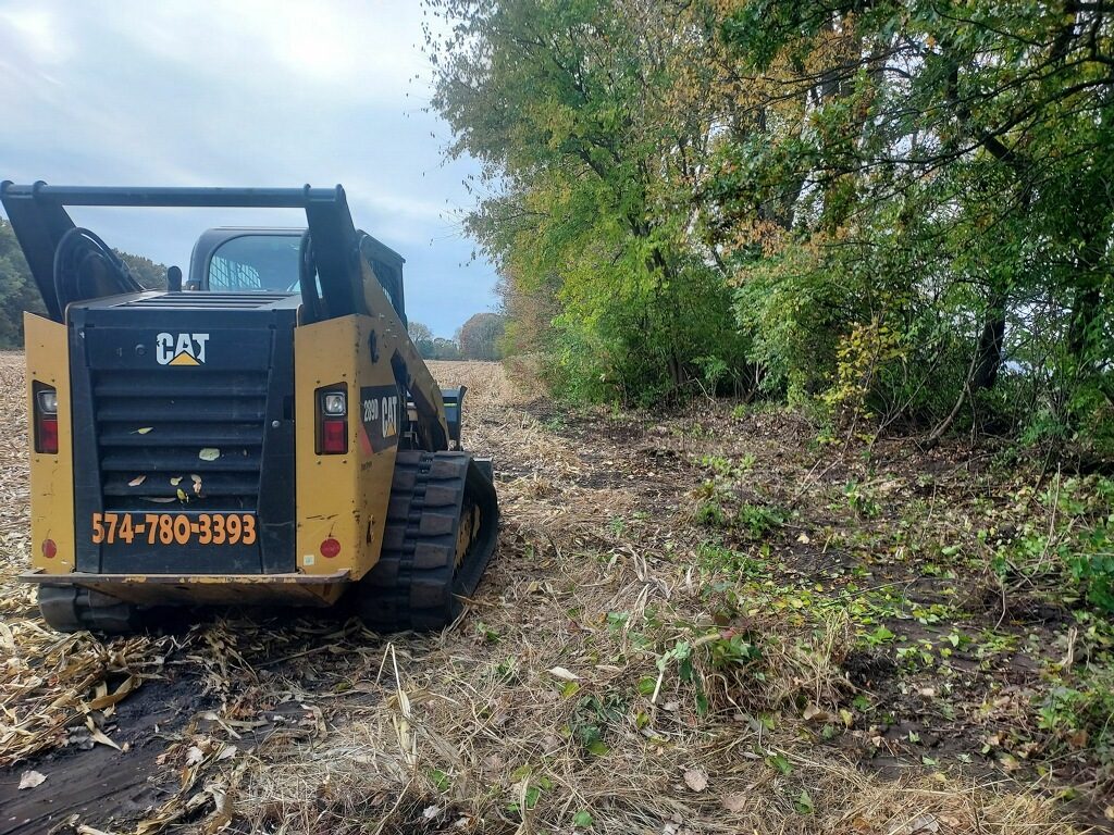 CAT skid loader clearing fence line in Northern Indiana