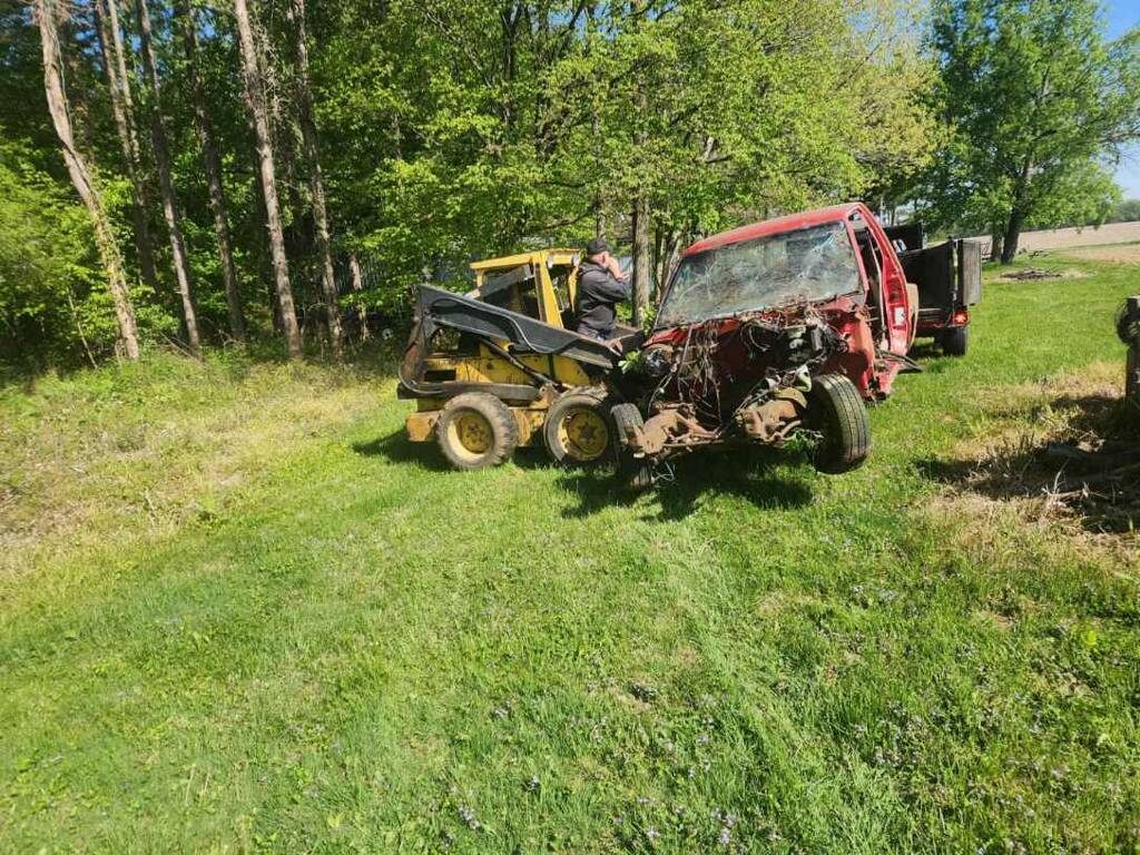 Skid loader removing wrecked truck from property in Northern Indiana